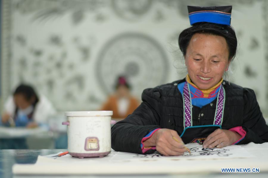 A female worker relocated from poverty-stricken area draws batik patterns at a batik workshop in Danzhai County of Guizhou Province in southwest China, Dec. 1, 2020. Wang Fangzhou, 40, started in August 2016 a workshop specialized in batik, a craft inherited through generations among the Miao ethnic group in Guizhou. Later on, he launched a batik experience gallery in Wanda Township, a local tourist attraction. His workshop and gallery have received more than 6,000 tourists so far this year with combined sales revenue of over 300,000 yuan (about 45,500 U.S. dollars). Thirteen residents relocated from poverty-stricken areas have found employment with decent salaries here. (Xinhua/Yang Ying)