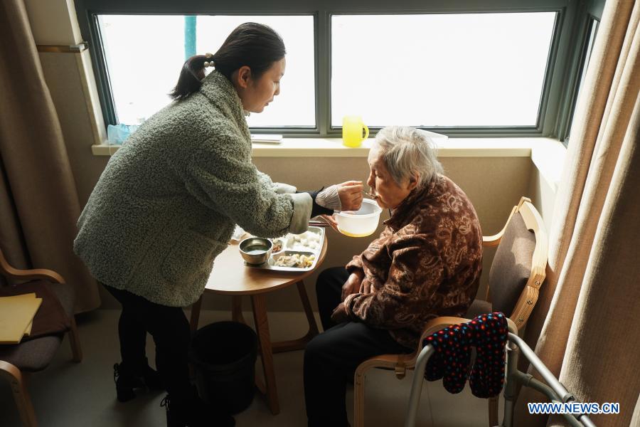 Song Weiqin (L) feeds her mother Yan Caijin at a community elderly care center in the Suzhou Industrial Park in Suzhou, east China's Jiangsu Province, Dec. 1, 2020. The elderly care center recently welcomed its clients back upon completion of a two-year renovation project that had fundamentally upgraded this facility from an ordinary nursing home. A professional management and operation team was also introduced to ensure quality services to the senior people living there. (Xinhua/Ji Chunpeng)