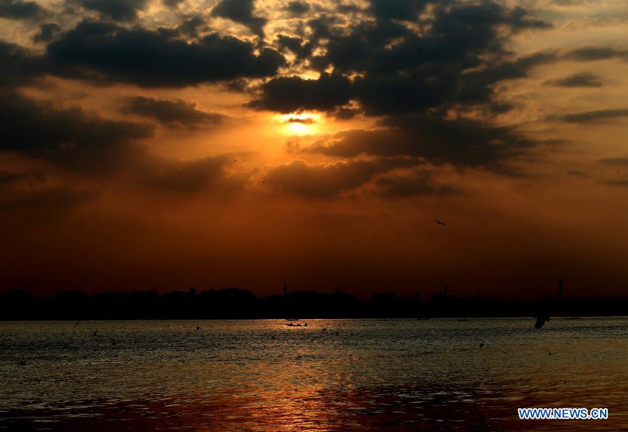 Photo taken on Dec. 1, 2020 shows birds flying over the Yangon river during the sunset at Botahtaung harbour in Yangon, Myanmar. (Xinhua/U Aung)