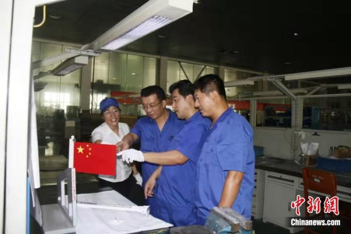 中国航天科工国旗展示系统研制团队研讨制造工艺。图源:中国航天科工集团