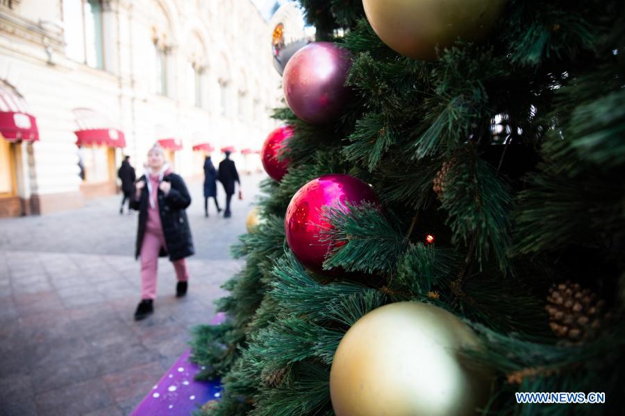 People walk by a Christmas tree with New Year decorations in Moscow, Russia, on Dec. 2, 2020. (Xinhua/Bai Xueqi)