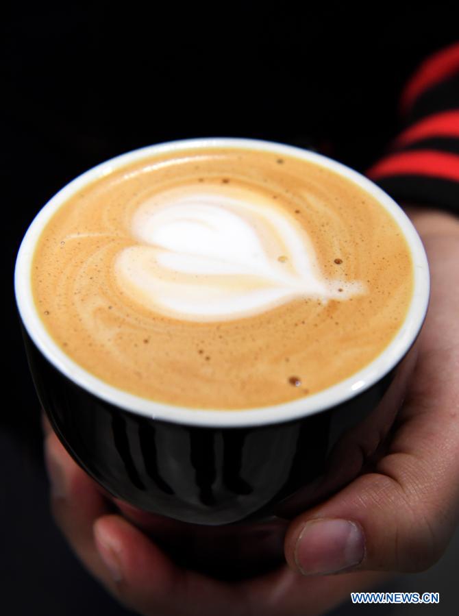 Photo taken on Dec. 1, 2020 shows a cup of coffee made by staff member Li Tao in Silence Coffee in Xincheng District of Xi'an, northwest China's Shaanxi Province. Silence Coffee, a coffee shop opened in Xi'an more than two months ago, is also a business incubator established for disabled people. Three of the four staff members in Silence Coffee are hearing-impaired baristas. They communicate with customers with sign language or typing on cellphone. Working on two shifts, all four members carried out routine work in the coffee shop including coffee making, baking, guest receiving and cleaning. Wang Lichao, manager of Silence Coffee, has learned sign language so as to better guide and 