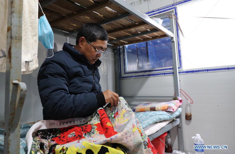 Zhang Xingfa works on a piece of cross-stitch in his temporary shed in east China's Shanghai Municipality, Dec. 2, 2020. Zhang Xingfa, 54, is an experienced welder currently working at a construction site in the Lingang Special Area in Shanghai. He accidentally had a first-hand experience with the art of cross-stitch years ago, and could never break away since then. Zhang takes great pleasure in cross-stitch, and sees the similarity between his hobby and his profession - they both command a lot of patience and precision. (Xinhua/Fang Zhe)