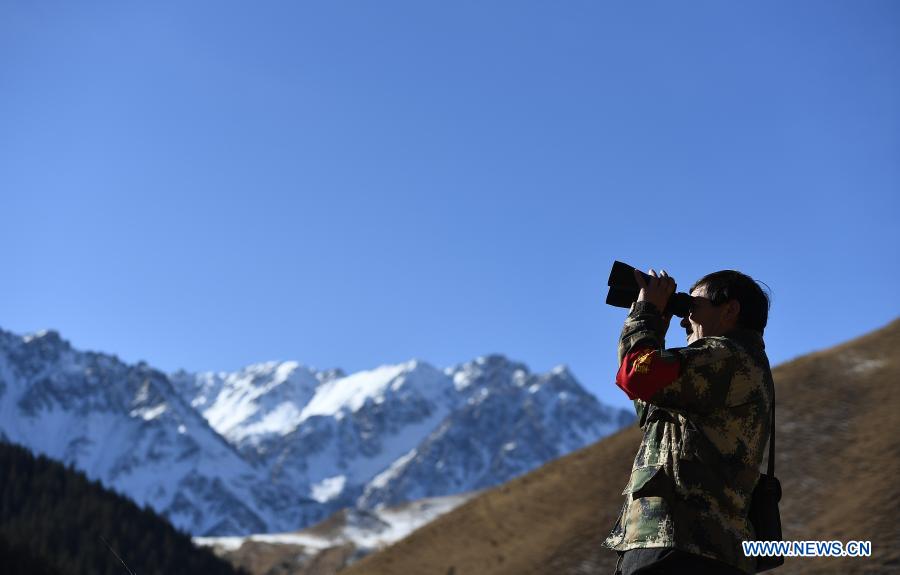 A ranger of the Zhamashi management and protection station looks through a pair of binoculars during a patrol task in the Qilian Mountain National Park in northwest China's Qinghai Province, Dec. 8, 2020. There are currently 228 rangers working at the Zhamashi management and protection station, which is located within the Qilian Mountain National Park. The rangers, trek 20 kilometers every day in patrols, shoulder the responsibility of keeping the park's forests safe as well as monitoring its flora and fauna resources. (Xinhua/Zhang Hongxiang)