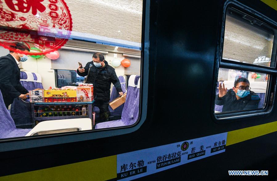 Photo taken on Dec. 9, 2020 shows passengers on train K9756 from Korla to Yetimbulak at the Korla railway station in Korla City of northwest China's Xinjiang Uygur Autonomous Region. The train will run on the Xinjiang section of the Golmud-Korla railway. The 1,206 km Golmud-Korla railway linking Golmud City in Qinghai Province and Korla City in Xinjiang Uygur Autonomous Region, both in northwest China, was put into operation on Wednesday. The new rail artery, which will cut the travel time between Golmud and Korla from about 26 hours to roughly 12 hours, is the third railway line facilitating exchanges between Xinjiang and other regions. The line also connects with the Qinghai-Tibet Railway, the world's highest rail system, and the network as a whole will link Xinjiang, Qinghai and the Tibet Autonomous Region, facilitating exchanges in western China. (Xinhua/Wang Fei)