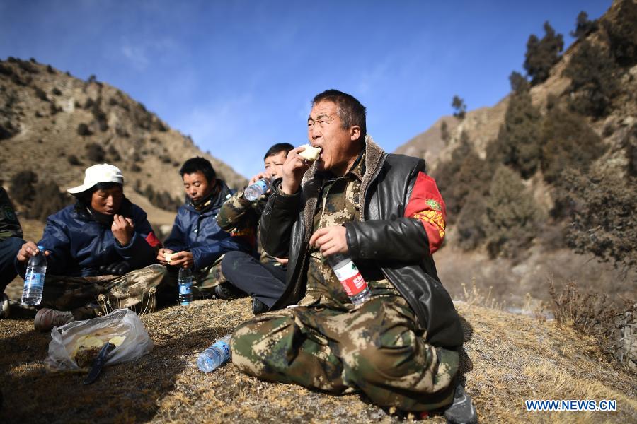 Rangers of the Zhamashi management and protection station have a brief lunch during a patrol task in the Qilian Mountain National Park in northwest China's Qinghai Province, Dec. 8, 2020. There are currently 228 rangers working at the Zhamashi management and protection station, which is located within the Qilian Mountain National Park. The rangers, trek 20 kilometers every day in patrols, shoulder the responsibility of keeping the park's forests safe as well as monitoring its flora and fauna resources. (Xinhua/Zhang Hongxiang)