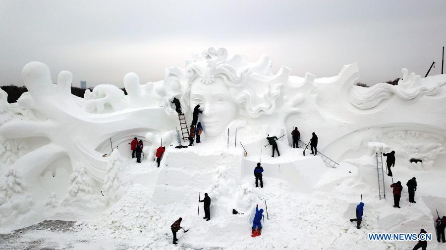 Aerial photo taken on Dec. 10, 2020 shows snow sculptors processing an artwork in the compound of the 33rd Harbin Sun Island International Snow Sculpture Art Exposition in Harbin, northeast China's Heilongjiang Province. The event is expected to open in mid-to-late November. (Xinhua/Wang Jianwei)