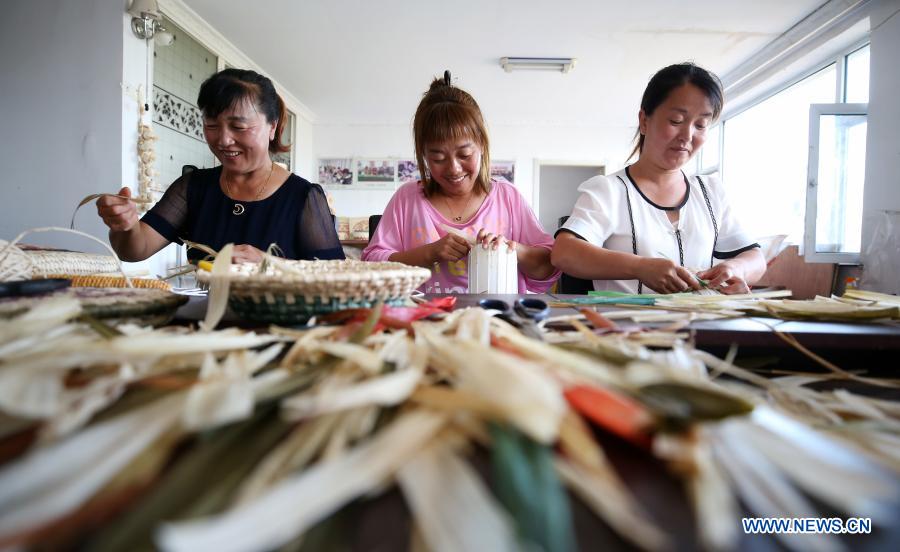 Villagers weave handiwork with straws and corn skins at a cooperative in Chunhua Village of Fushun Town in Taonan City, northeast China's Jilin Province, Aug. 12, 2020. China has removed all its 832 impoverished counties nationwide from the poverty list. Developing industries have played an important role in the country's poverty alleviation efforts, which will be still fundamental to continuously consolidate the poverty-relief achievements. Statistics from China's Ministry of Agriculture and Rural Affairs show that all 832 impoverished counties have carried out more than one million industrial projects and built over 300,000 industrial bases in total, with each county having 2-3 leading industries and up to 98% of impoverished people benefited. From poverty-relief workshop to industrial cooperatives, those once-impoverished counties have strived to continuously develop industries based on local conditions, as fundamental measures to consolidate poverty-relief achievements and revitalize rural areas. (Xinhua/Luo Yuan)