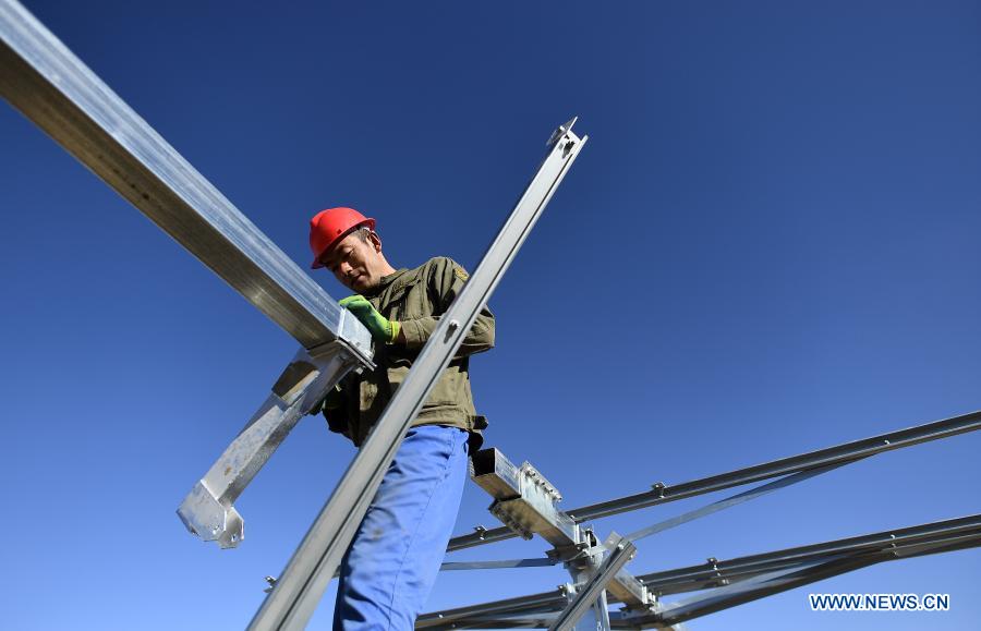 A worker installs a solar power unit at the construction site of a 300-MW photovoltaic electricity project of the China Datang Corporation Ltd. in Gonghe County, Tibetan Autonomous Prefecture of Hainan in northwest China's Qinghai Province, Dec. 15, 2020. (Xinhua/Zhang Hongxiang)