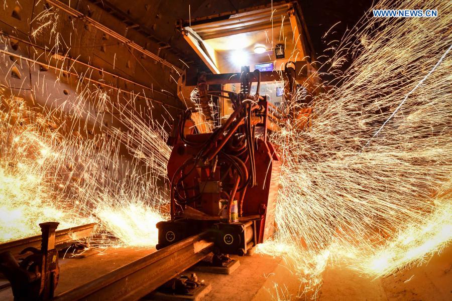 Sparks fly as a rail mobile flash butt welding machine works on the track of the Guangzhou Metro Line 18 in Guangzhou, south China's Guangdong Province, on Dec. 16, 2020. A total of 122.6 kilometers of railway tracks will need to be laid for the Guangzhou Metro Line 18, a subway line which is under construction with a maximum designed speed of 160 kilometers per hour. (Xinhua/Liu Dawei)