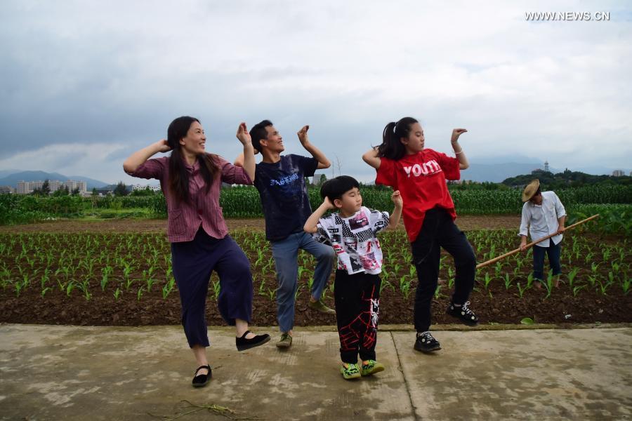 Peng Xiaoying (1st L) and Fan Deduo enjoy a dance with their children in a farm field in Xia'ao Village of Mayu Township, Ruian, east China's Zhejiang Province, June 1, 2020. When they are done with the farm work, Fan Deduo and his wife Peng Xiaoying have a big hobby -- choreographing dances and trying them out. Eighteen years ago, Fan was injured in a traffic accident and the trauma led him to suffer from depression. In 2016, he had decided to cope with depression by learning to dance with Peng. The couple now runs an evening livestream channel on video sharing platform Douyin, showing their new dances to over 1.4 million followers. Looking back at 2020, there are always some warm pictures and touching moments: the dedication on the front line to fight against the epidemic, the perseverance on the way out of poverty, the courage to shoulder the responsibility on the embankment against the flood, the joy and pride when reaching the summit of Mount Qomolangma... These people and things touch our hearts and give us warmth and strength. (Xinhua/Zheng Mengyu)