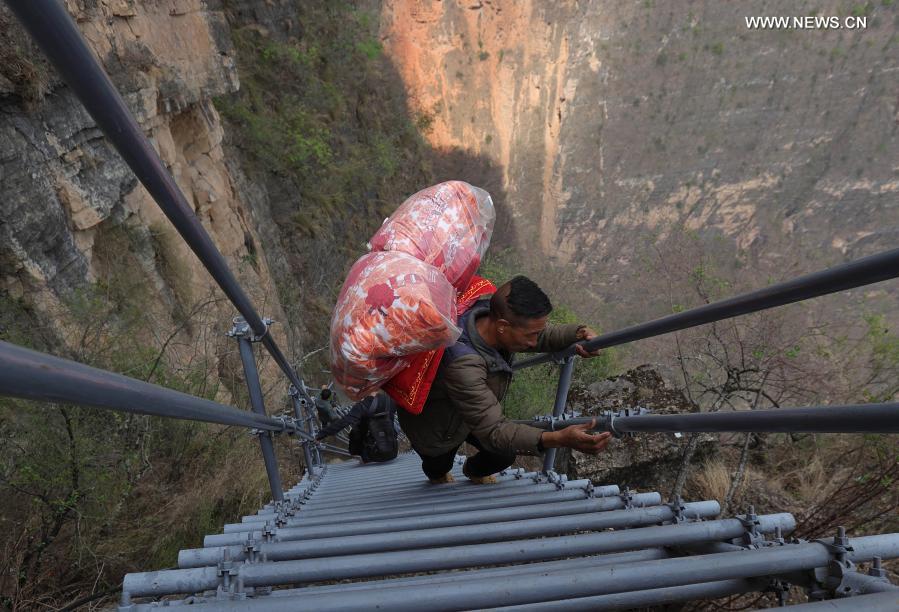 A villager goes down the steel ladder to leave Atulieer village and move to their new home at a newly-built community for poverty alleviation relocation in Zhaojue County, southwest China's Sichuan Province, May 13, 2020. Looking back at 2020, there are always some warm pictures and touching moments: the dedication on the front line to fight against the epidemic, the perseverance on the way out of poverty, the courage to shoulder the responsibility on the embankment against the flood, the joy and pride when reaching the summit of Mount Qomolangma... These people and things touch our hearts and give us warmth and strength. (Xinhua/Jiang Hongjing)