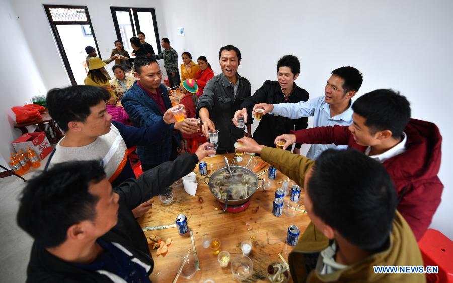 Residents of Gafeng Village in Baisha Li Autonomous County in south China's Hainan Province celebrate after moving to their new residence, Dec. 16, 2020. Gaofeng Village sits in central part of the Yinggeling National Nature Reserve, almost isolated from the outer world due to poor condition of mountainous trails. More than 100 families in the village had been living in deep poverty before 2015 as many of them had no access to electricity, mobile telecommunication, and Internet services. They nearly had no alternative source of income apart from rubber plantations. The first round of relocation was initiated in 2015 in Gaofeng Village both to preserve the ecological environment and to improve the residents' income, and 30 families moved to their new residence at foot of the hills in 2017. The second round of relocation followed in 2018 when authorities of Hainan Province decided to start a pilot rainforest national park there. The 100 families remaining in Gaofeng Village were relocated to their new residence merely 3 kilometers away from the prefecture seat of Baisha in December 2020. The local authorities offered 10 mu (or 0.67 hectares) of rubber plantation to each relocated villager, and provided employment and profit-sharing opportunities through edible fungi growing bases. (Xinhua/Guo Cheng)