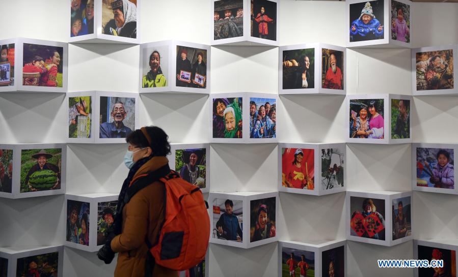 A visitor views photos reflecting China's fight against poverty at a photography exhibition during the 13th China Photography Festival in Sanmenxia City of central China's Henan Province, Dec. 20, 2020. The 13th China Photography Festival kicked off on Dec. 20 in the city of Sanmenxia in central China's Henan Province. This year's festival carries the theme of the country's fight against poverty and the COVID-19 epidemic. (Xinhua/Li Jianan)