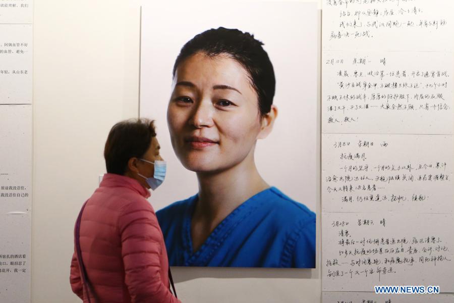 A visitor views photos reflecting China's fight against the COVID-19 epidemic at a photography exhibition during the 13th China Photography Festival in Sanmenxia City of central China's Henan Province, Dec. 20, 2020. The 13th China Photography Festival kicked off on Dec. 20 in the city of Sanmenxia in central China's Henan Province. This year's festival carries the theme of the country's fight against poverty and the COVID-19 epidemic. (Xinhua/Xu Yanan)