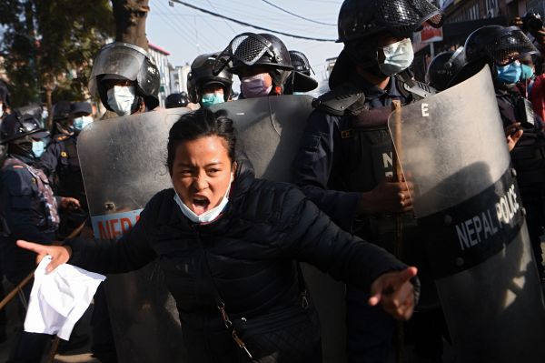 尼泊尔总统宣布解散众议院后，一名抗议者20日在加德满都与警察对峙。（法新社）