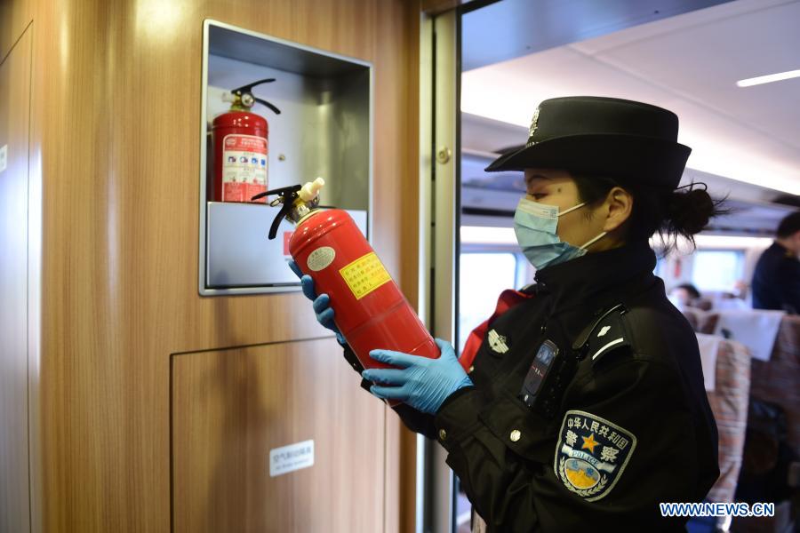A police officer checks fire-fighting gears on train No. G8311 from Hefei City to Anqing City, in east China's Anhui Province, Dec. 22, 2020. The Hefei-Anqing section of the Beijing-Hong Kong high-speed railway was put into operation Tuesday. Cities of Hefei and Anqing, both in Anhui Province, are critical hubs where several other major railway tracks intersect. The 176-kilometer section of tracks allow trains to run at a designed speed of 350 kilometers per hour on them. (Xinhua/Huang Bohan)