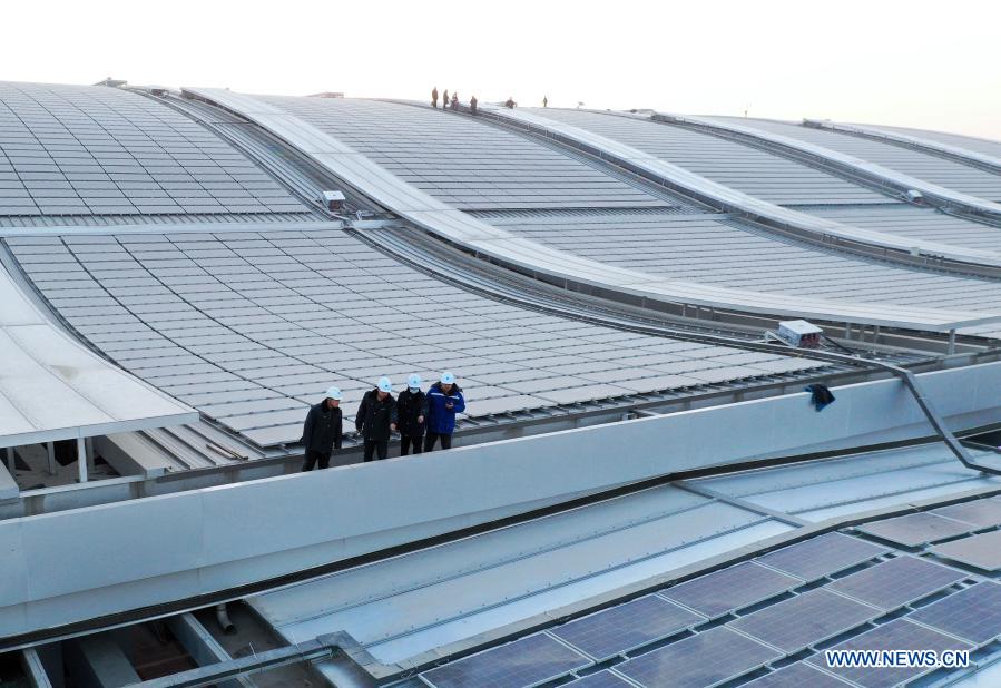 Aerial photo shows workers working on the roof of Beijing-Xiongan intercity railway's Xiongan Railway Station in Xiongan New Area, north China's Hebei Province, Dec. 21, 2020. The construction of Beijing-Xiongan intercity railway's Xiongan Railway Station has entered the final stage and the station will be put into operation by the end of this year. (Xinhua)