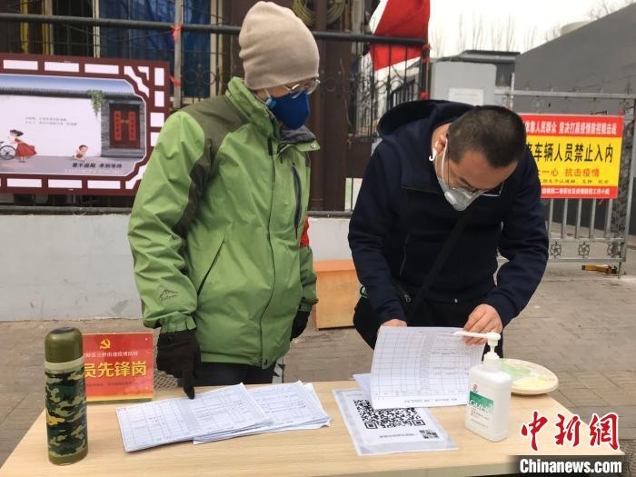杨代华被安排值守小区,检查出入人员的“出入证”。 李怡 摄