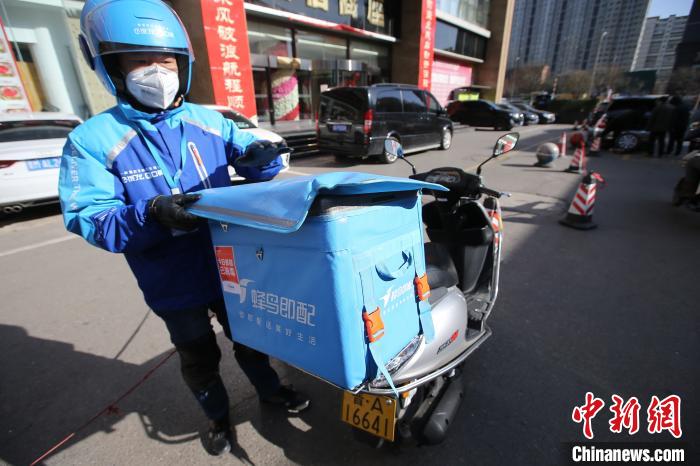 疫情期间,外卖员佩戴口罩,每天会进行体温检测,配送箱会进行全面消毒。 张云 摄