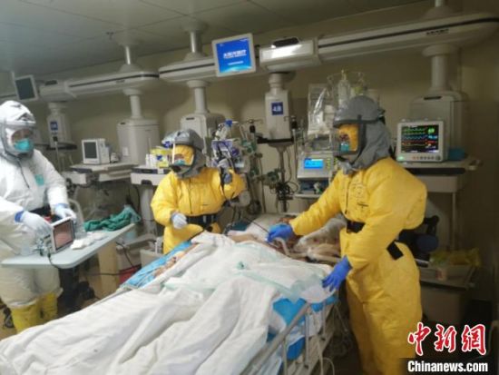 负压病房医护人员在床边为危重型新冠肺炎患者做纤维支气管镜.