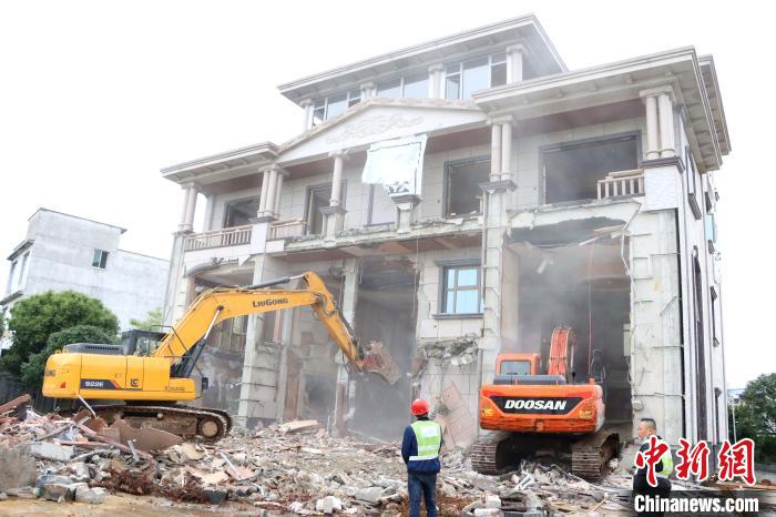 图为挖掘机在拆除大毒枭张加爱涉毒涉黑违法建筑。 徐肖玲 摄