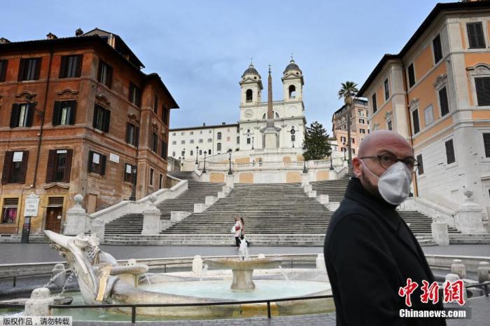 资料图：当地时间3月12日，意大利罗马市中心斯帕尼亚广场，一名戴着防护面具的男子走过台阶。