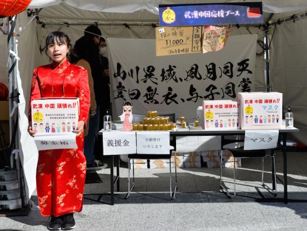 2020年2月8日,日本东京池袋,一位身穿红色旗袍的日本少女手捧募捐箱为武汉募捐。新华社 图