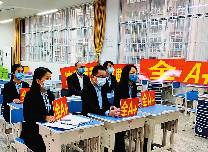 南宁四十七中校长陆东旭和任课教师手持A+牌给毕业班学生“云”致辞(学校供图)
