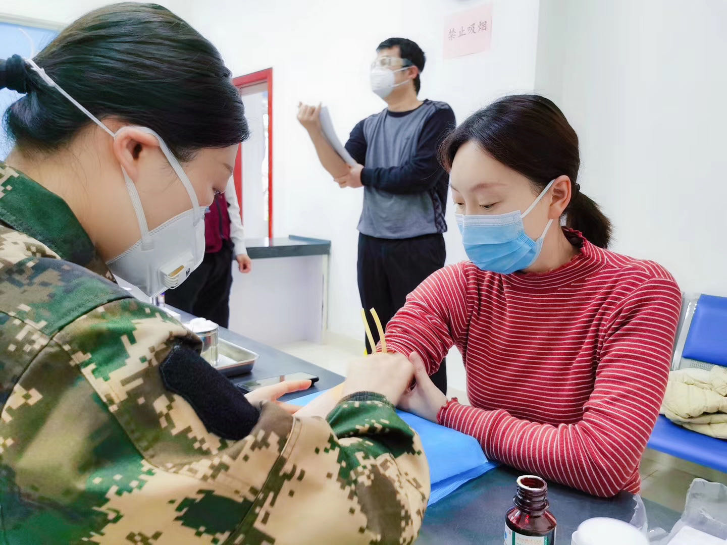 工作人员为靳官萍采血。
