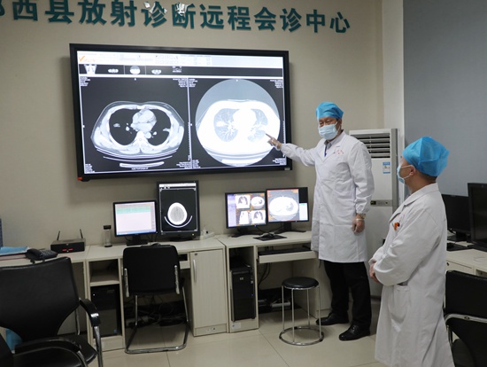 夏进东（左）和郧西县人民医院的医护人员分享CT摄片情况。受访者供图