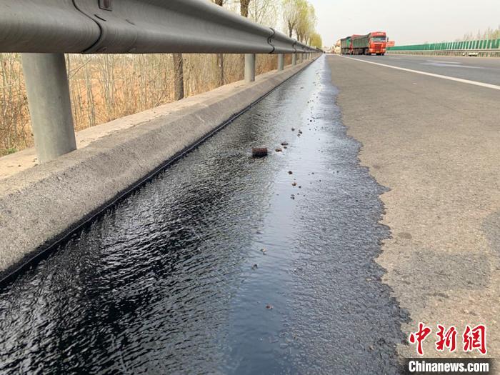 外泄的汽油沿着高速公路流淌200多米。张帅 摄