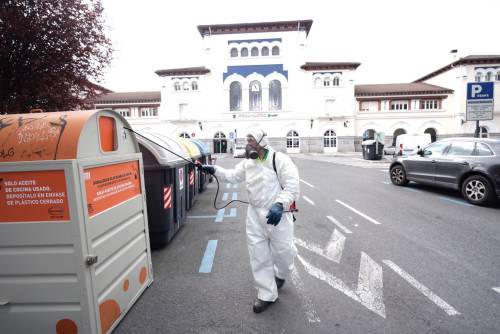 3月24日,在西班牙巴斯克自治区的维多利亚,一名市政工作人员为垃圾箱消毒。新华社/欧新