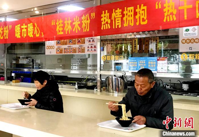 3月30日,湖北籍人员在广西桂林市七星区桂林米粉文化中心品尝桂林米粉。 王亚东 摄