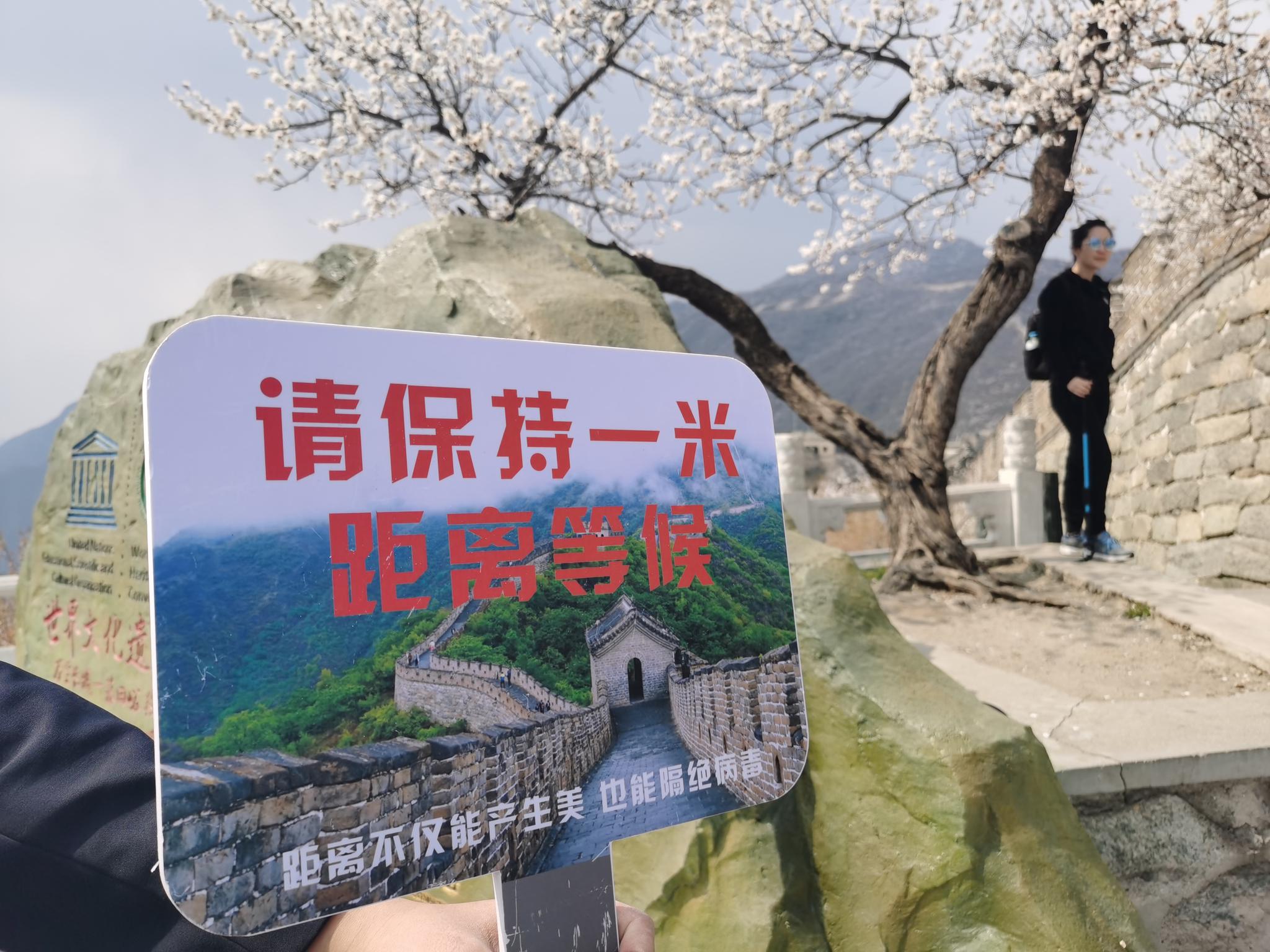 沿途也设有提醒游客保持一米距离的提示牌。新京报记者 王颖 摄