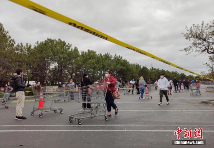 当地时间4月8日,美国旧金山湾区民众在位于福斯特城的Costco超市外排起长队,等候购买物资。中新社记者 刘关关 摄