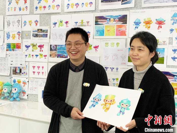 张文(左)与其妻子杨毅弘展示吉祥物。 张斌 摄