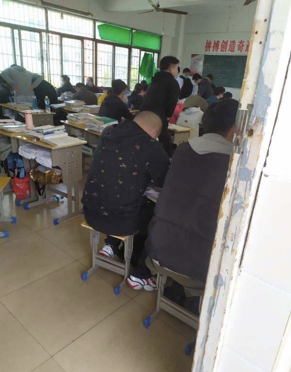 网友提供的照片表现,课堂中每两张书桌挨在一路,课堂中约有五十余张书桌,门生均佩带口罩。 图源:微博