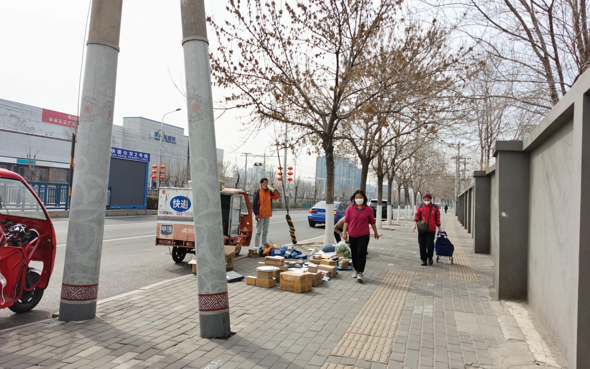 允许快递员办出入证进小区后,京通苑小区南门外的快递“摆摊”量减少。摄影/新京报记者 陈琳