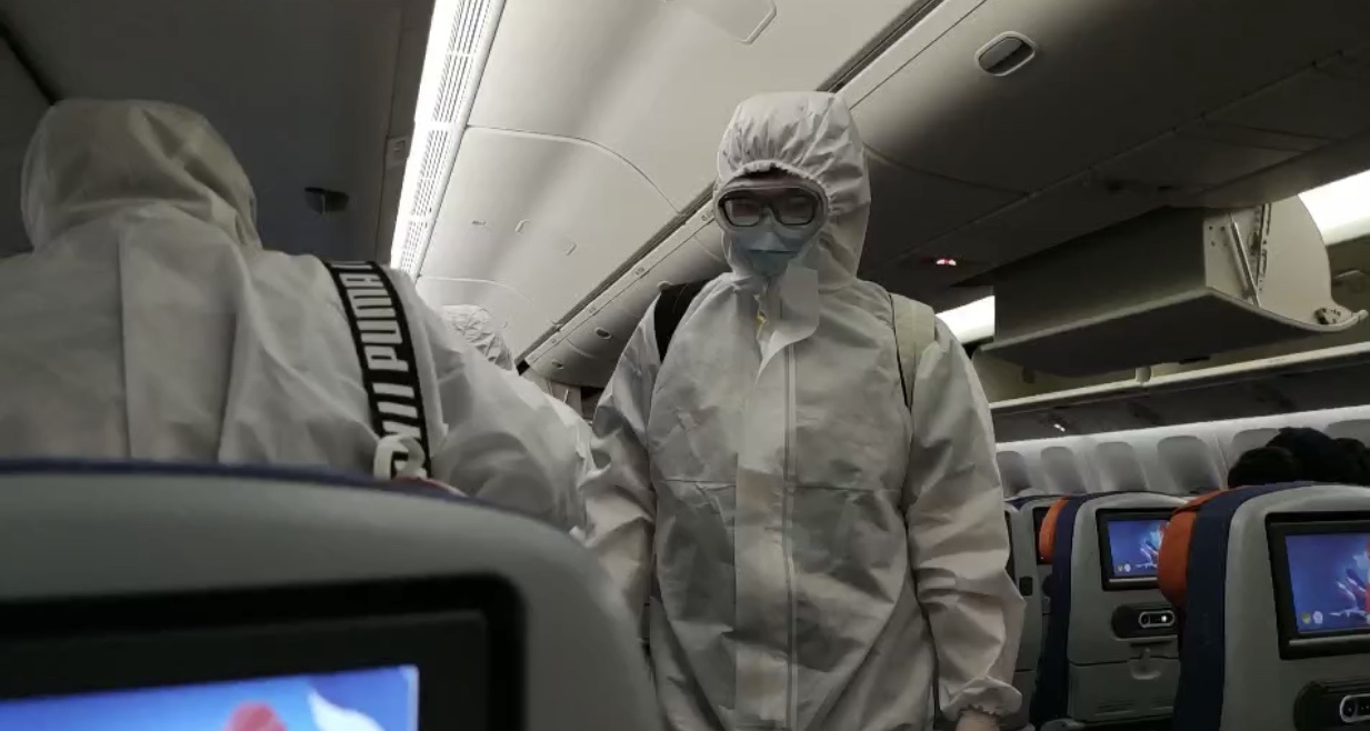 航班上大多数旅客佩戴口罩、护目镜,身穿防护服。受访者供图
