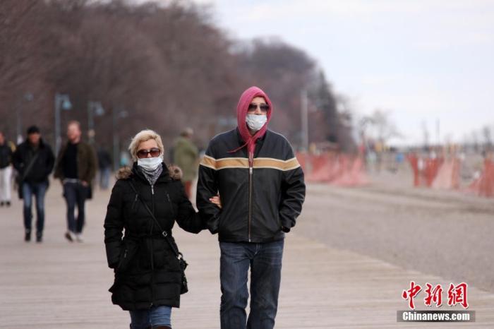 当地时间4月11日,复活节假期,加拿大多伦多市民佩戴口罩在湖滨公园散步踏青。 中新社记者 余瑞冬 摄