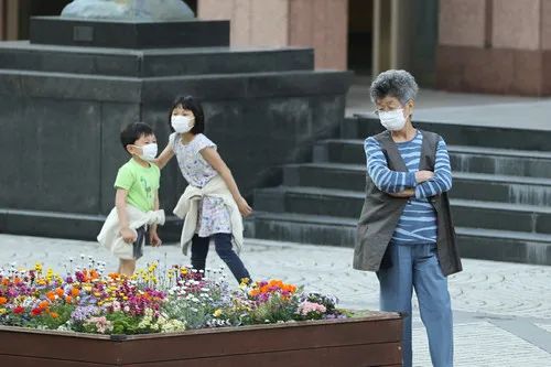 ▲4月8日,在日本东京,老人和小孩戴口罩在户外休闲放松。(新华社记者 杜潇逸 摄)