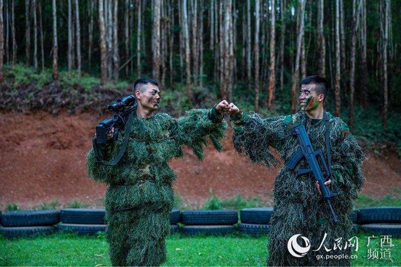 图为完成潜伏狙击任务后的乐聚(左)和许海鹏(右)击拳互勉。余海洋摄