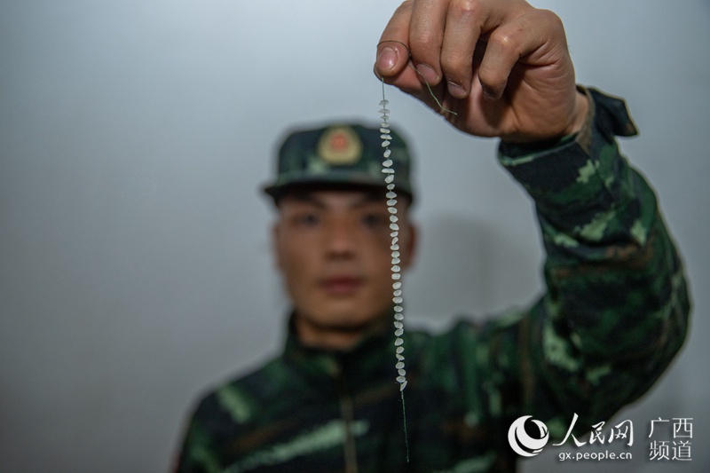 图为乐聚展示自己穿米粒的成果。余海洋摄