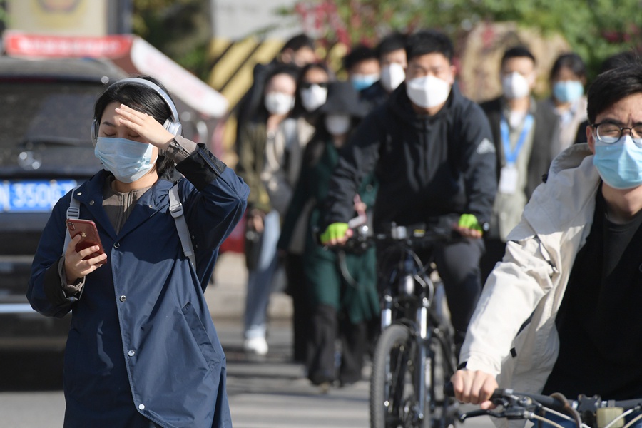 北京:疫情期间市民戴口罩骑行上班