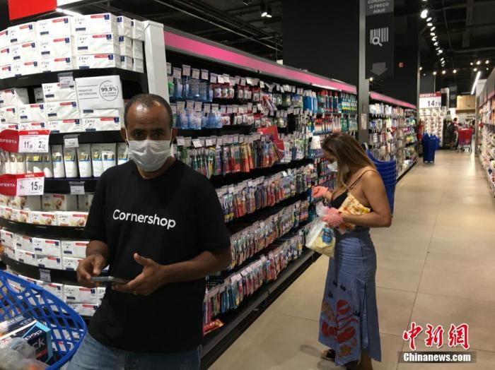 当地时间4月9日,在巴西圣保罗,民众戴着口罩在一家超市购物。