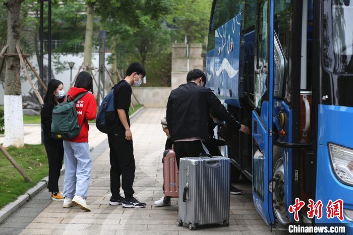 学生将行李拿下车。 朱柳融 摄