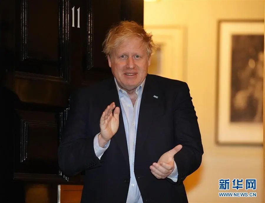 ▲4月2日晚,英国首相约翰逊在伦敦唐宁街11号门口为NHS医护人员鼓掌。(新华社发)