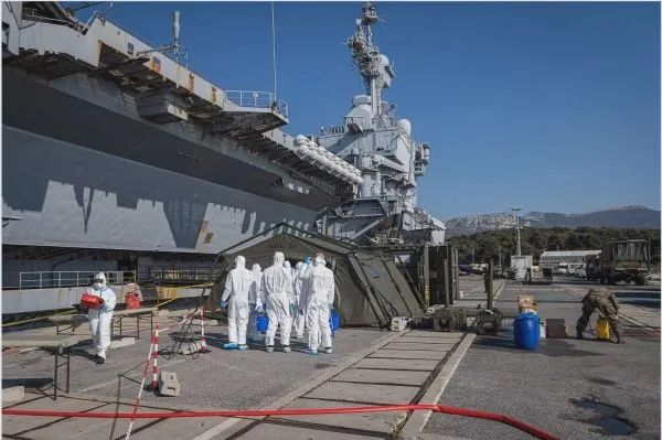 ▲法军人员在“戴高乐”号航母旁进行防疫作业。（法国海军网站）