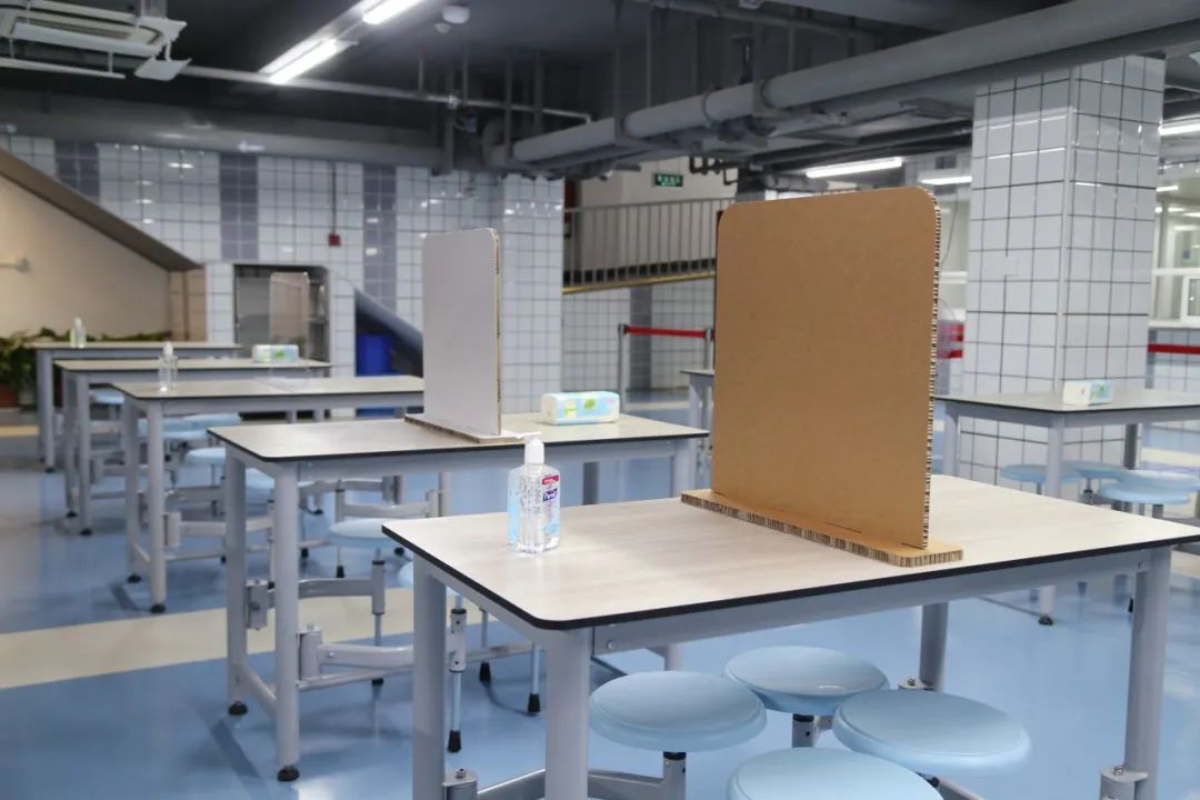 学校按要求在餐桌上安装了隔板(图为在黄浦区教诲学院隶属中山学校、敬业中学拍摄的画面)。
